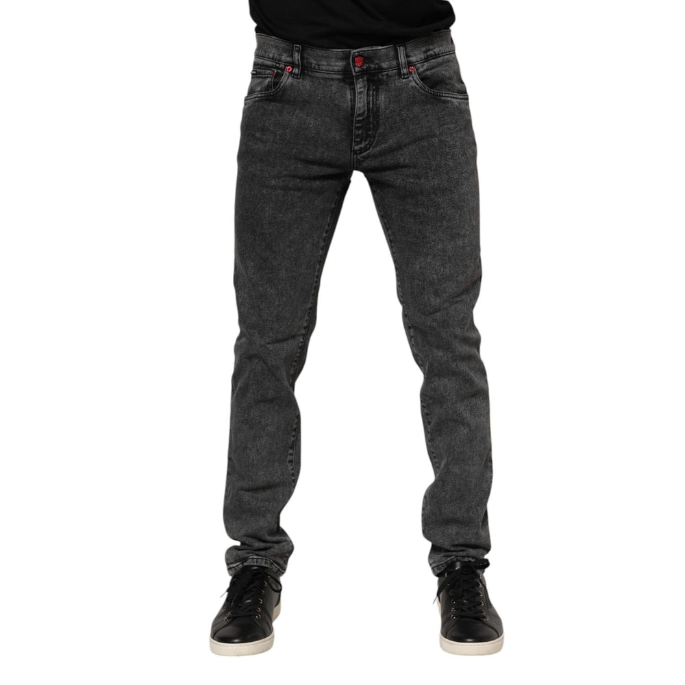 Man wearing Dolce & Gabbana black washed denim jeans with zipper closure and logo plaque detail, skinny fit.
