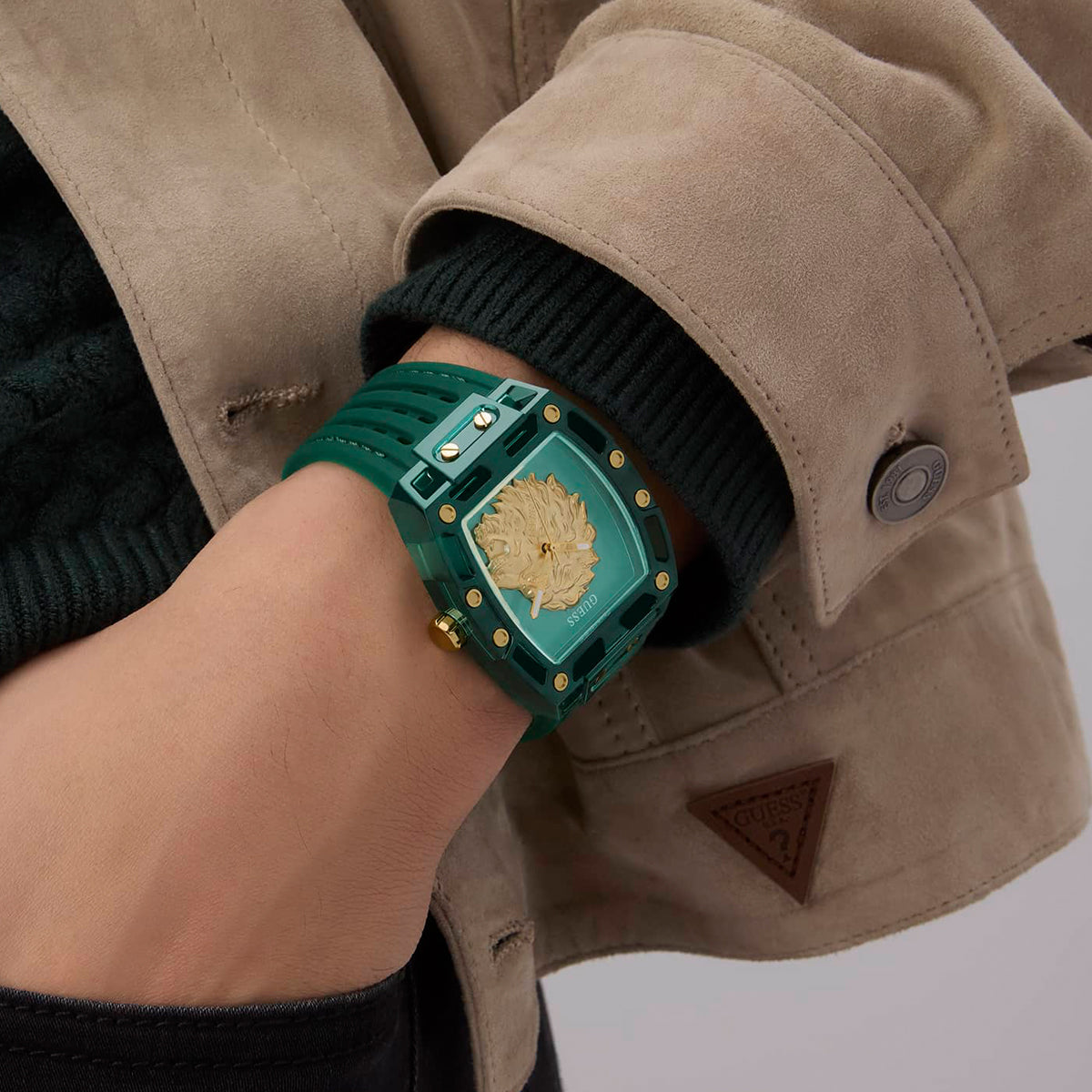 Stylish green wristwatch worn with beige jacket, featuring GUESS Mod. PHOENIX design, showcasing fashion-forward elegance.