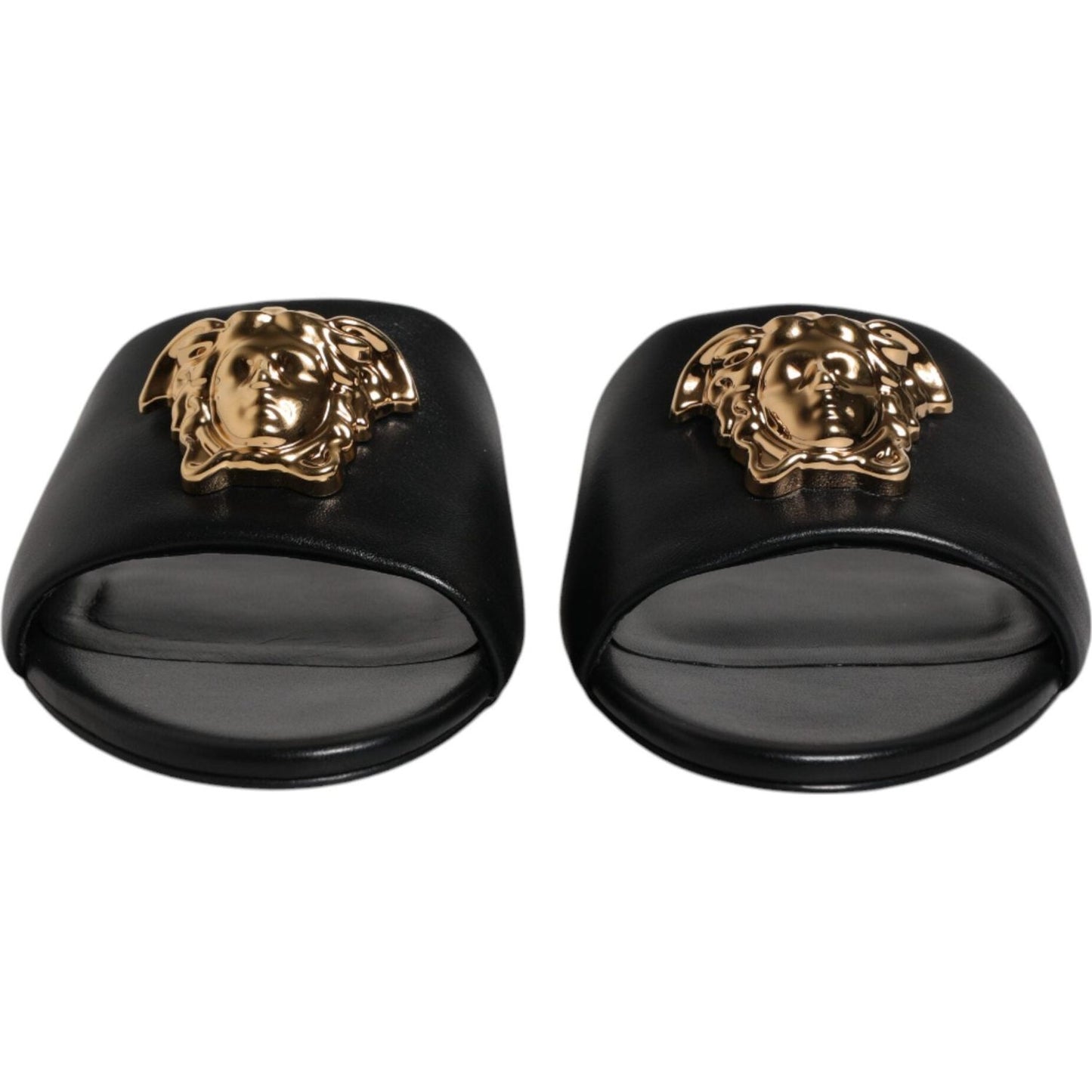 Versace black leather slip-on slides with gold logo plaque, open toe, high-quality, luxurious design, ideal for comfort, made in Italy.