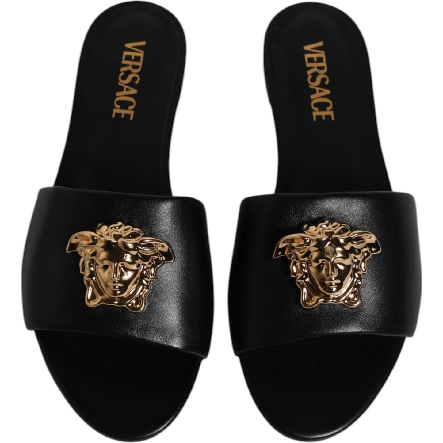 Versace black leather slip-on slides with gold logo plaque, open toe, made in Italy. High-quality craftsmanship, stylish and comfortable.