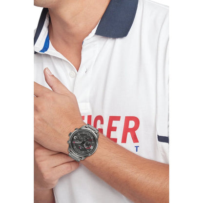 Man wearing TOMMY HILFIGER Mod. 1792071 quartz analog watch, 46mm case, and mineral dial, shown with official packaging bracelet style.