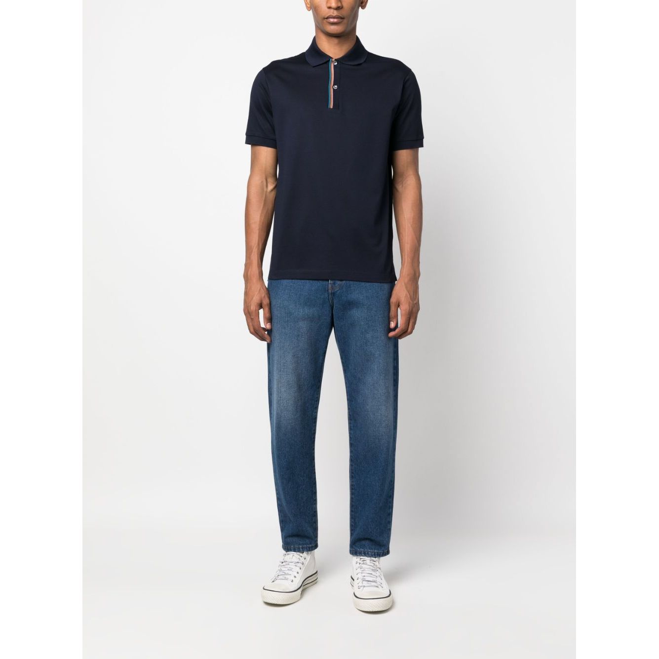 Man wearing PS By Paul Smith T-shirts and Polos Blue featuring rainbow-stripe cotton polo shirt in navy blue with jeans and sneakers.