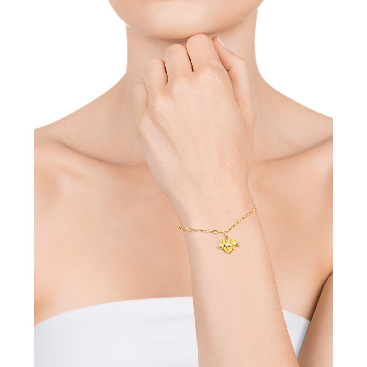 Woman wearing a gold bracelet with a heart charm, demonstrating Viceroy Jewels' elegant design for ladies.