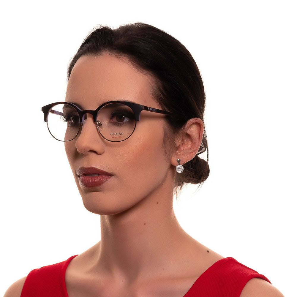 Woman wearing Guess Brown Women Glasses Frame, full-rim round frames with metal and plastic material, showcasing elegant look.