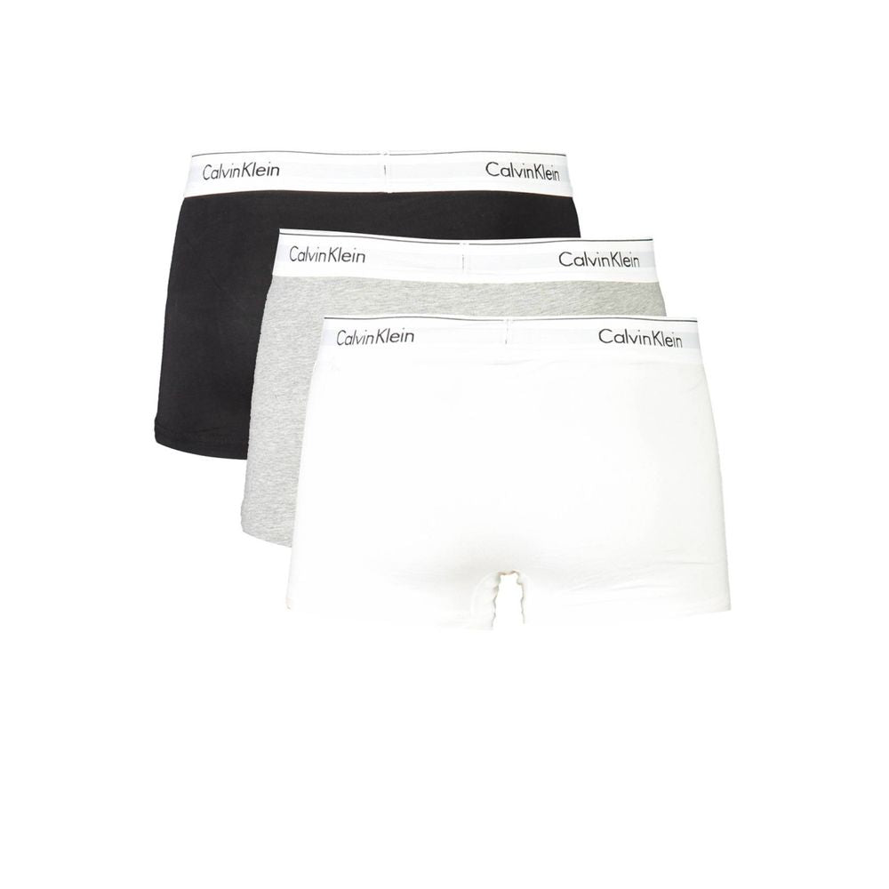 Calvin Klein tri-pack boxers in black, grey, and white with iconic logo waistband.