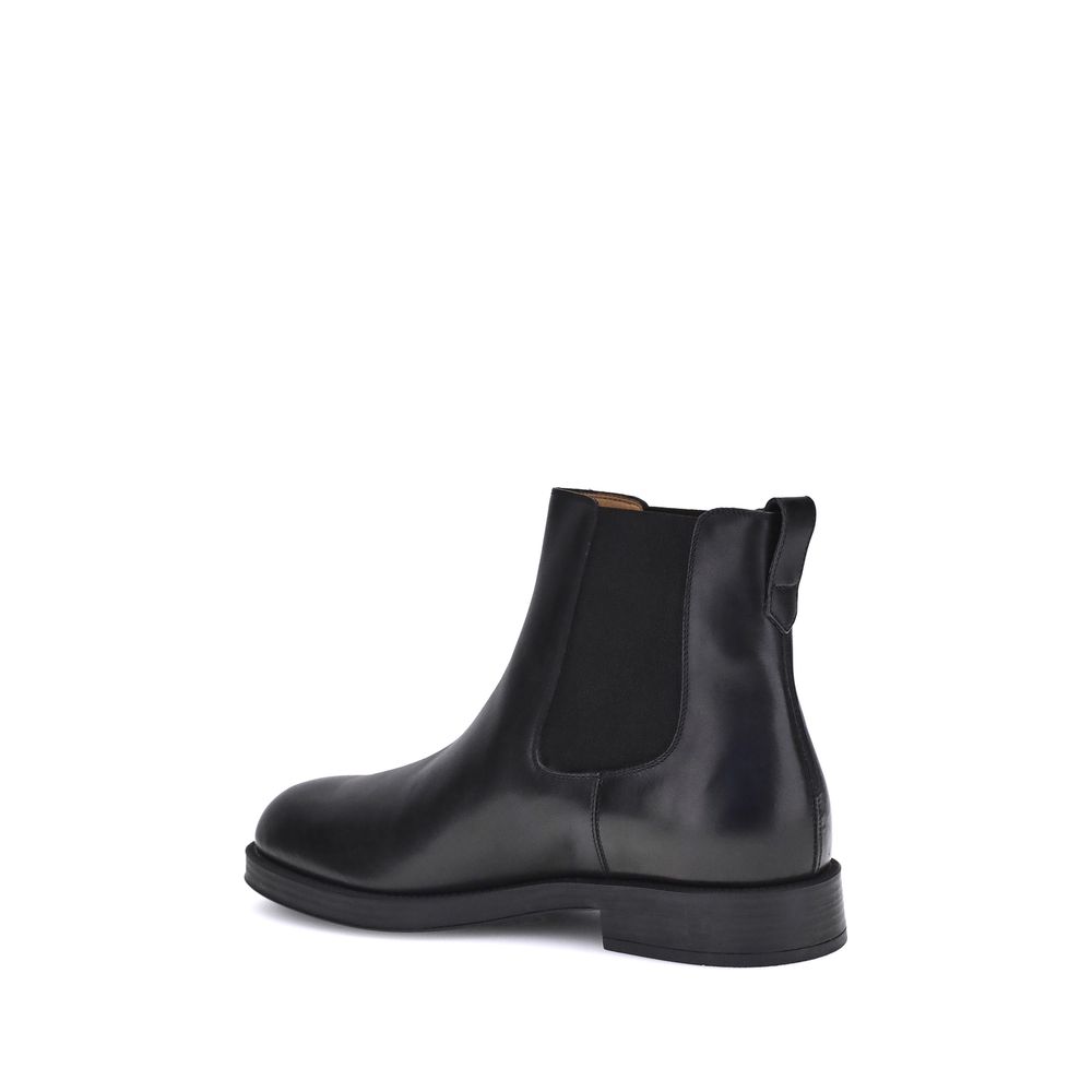 Alt Tag: Side view of Tod's Black Calf Leather Bos Taurus Chelsea Boots with elastic side inserts and back tab.