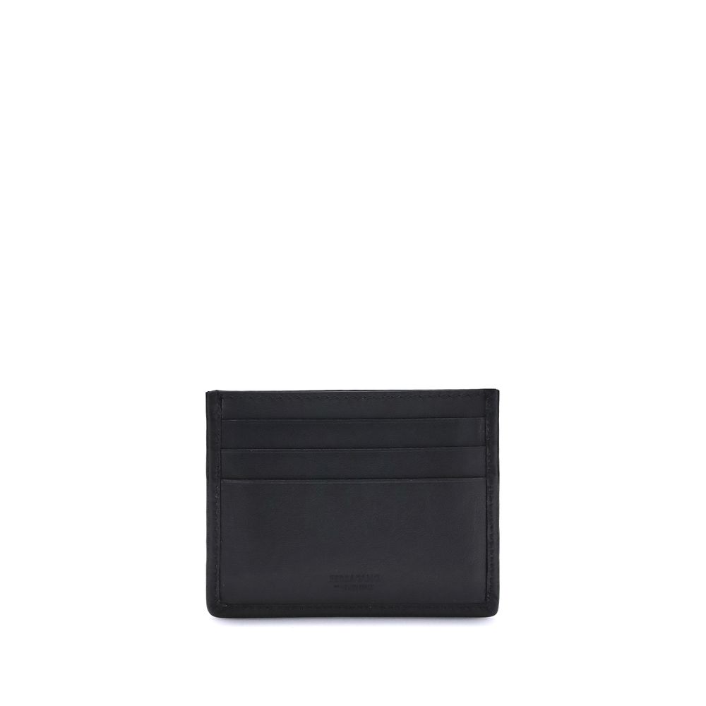Ferragamo Black Calf Leather Bos Taurus Wallet with card slots and palladium Gancini ornament on black background.