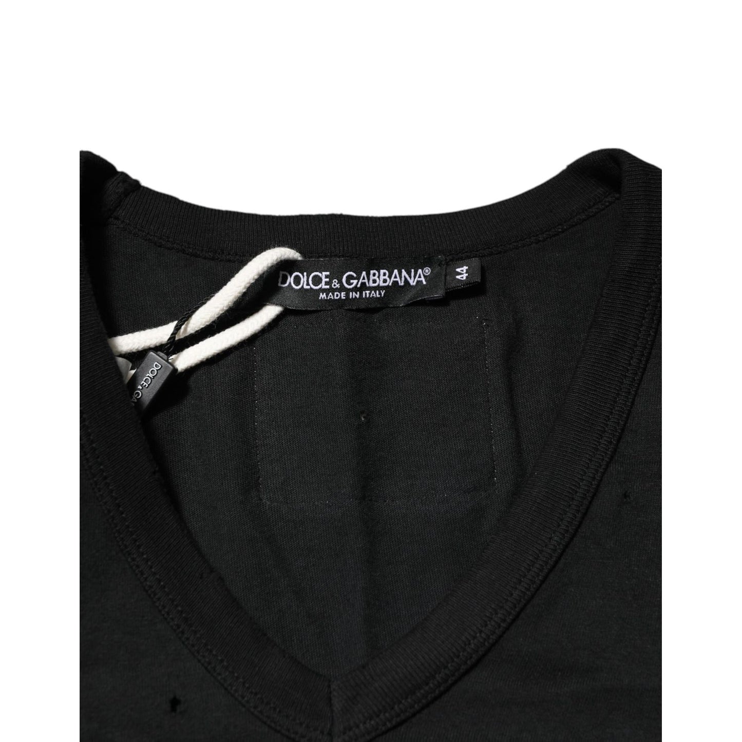 Close-up of Dolce & Gabbana Black Cotton Tattered Logo V-Neck Men T-shirt, featuring punched-hole design and black fabric label.