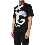 Dolce & Gabbana Black Cotton DG Logo Graffiti Short Sleeve T-shirt with oversized white graffiti-style logo on a model.
