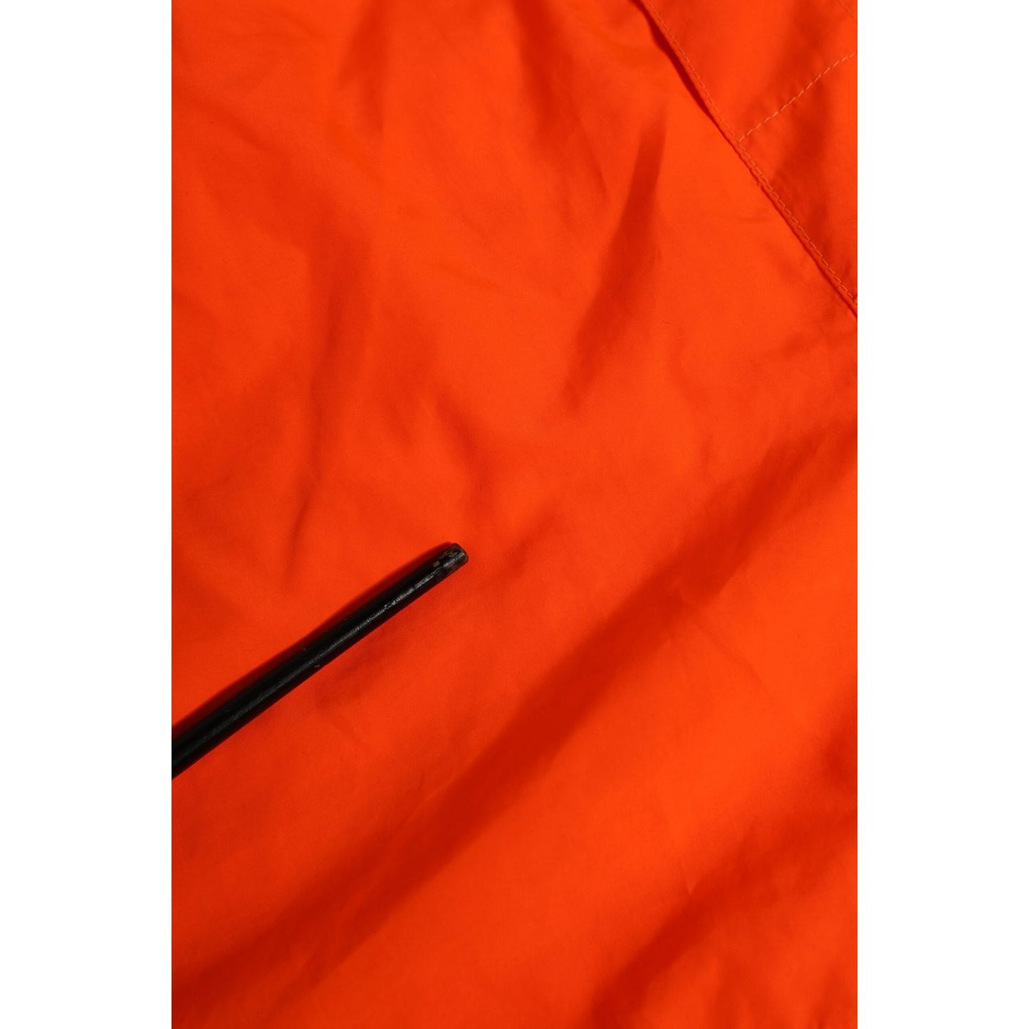 Close-up of Dolce & Gabbana Orange Polyester Beachwear Men Shorts Swimwear with zip pocket detail, elastic waistband visible.