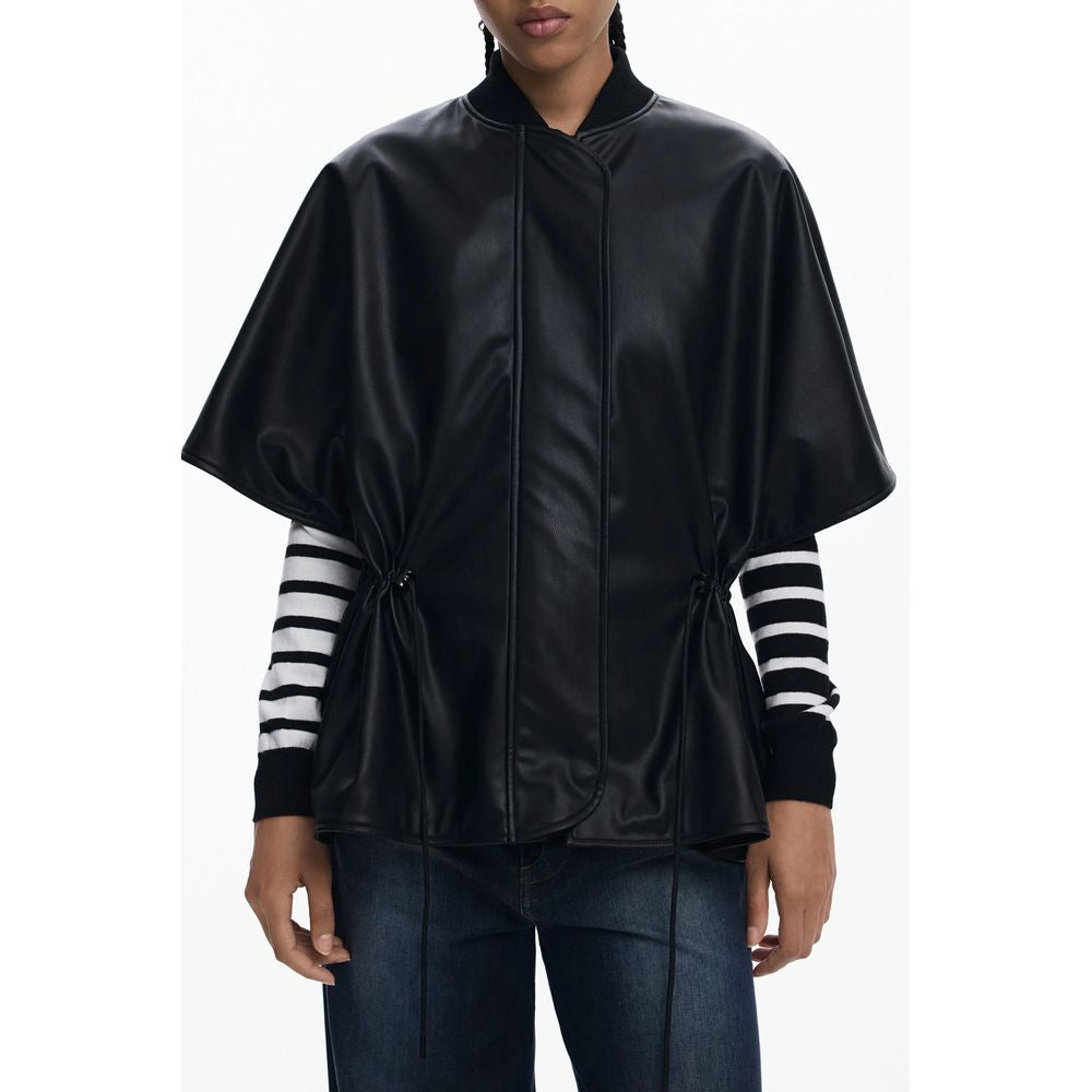 Woman wearing a Desigual Black Polyethylene Women Poncho with stripe sleeves, featuring a drawstring waist and embossed design.