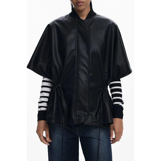 Woman wearing a Desigual Black Polyethylene Women Poncho with stripe sleeves, featuring a drawstring waist and embossed design.