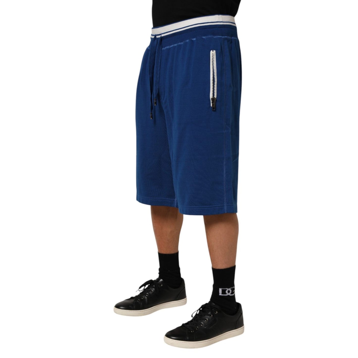 Man wearing Dolce & Gabbana Blue Cotton Blend Bermuda Sweatpants Shorts with elastic waistband and drawstring, side view