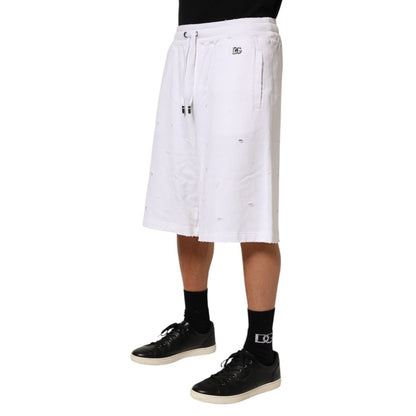 Model wearing Dolce & Gabbana White Cotton Ripped Bermuda Sweatpants Shorts with elastic waistband and drawstring for casual styling.