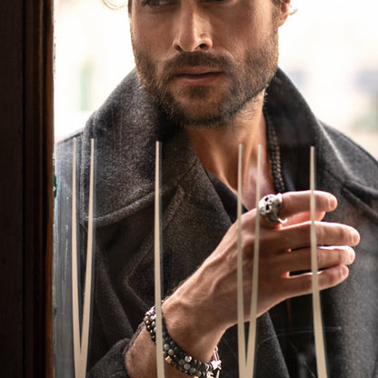 Man wearing dark coat and ring, showcasing AN JEWELS JEWELRY Mod. AA.R255S-11, beside a window with reflective lines.