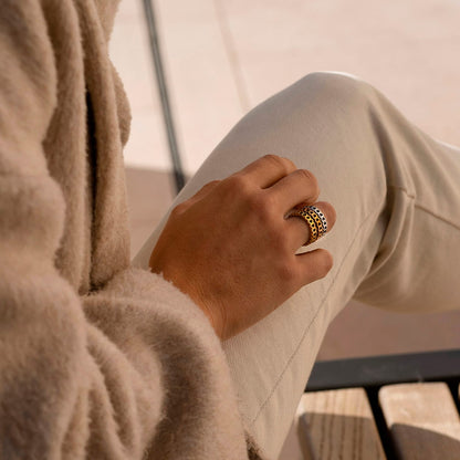 Person wearing AN JEWELS JEWELRY Mod. AL.RSC01SYR-9 ring on finger, dressed in cozy beige coat and pants.