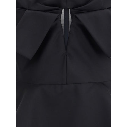 Close-up of Alexander McQueen Black Polyester Top showing bow detail and peplum silhouette.