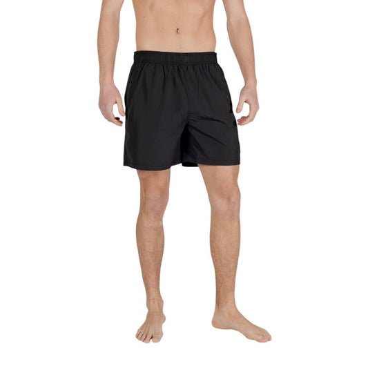 Model wearing Armani Exchange Black Polyester Swim Shorts showcasing elastic waistband and minimal design.