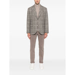 Man wearing Brunello Cucinelli Cashmere Zipped Cardigan under checkered blazer with brown pants and white shoes.