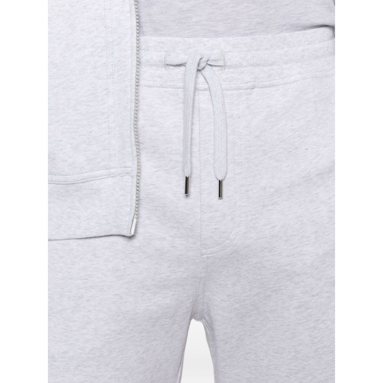 Close-up of Brunello Cucinelli Cotton track pants in light grey showing elasticated drawstring waistband and side slit pockets.