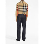 Man wearing Burberry Check cotton shirt with classic collar and archive beige check print, styled with dark jeans, back view