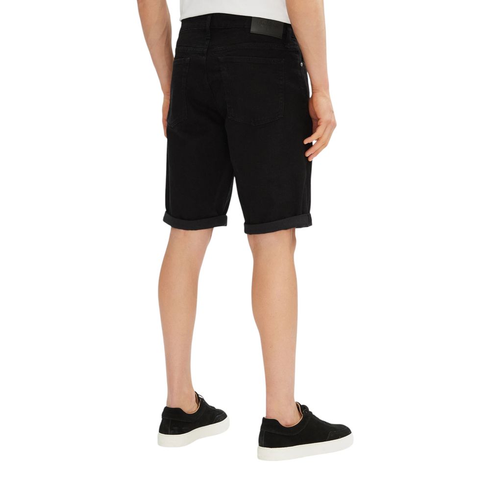 Back view of a model wearing Calvin Klein Jeans Black Cotton Bermuda Shorts, highlighting slim fit design and comfort for summer wear.