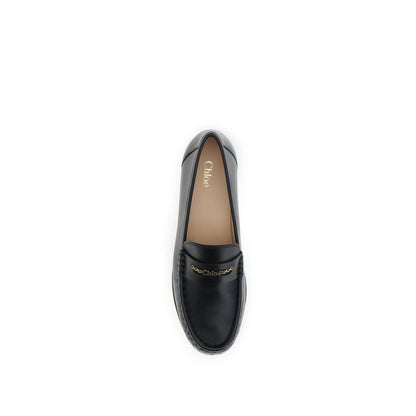 Chloé Black Calf Leather Bos Taurus Slip-On Loafers with gold chain detailing and pleated design. Stylish AW25 fashion footwear for women.
