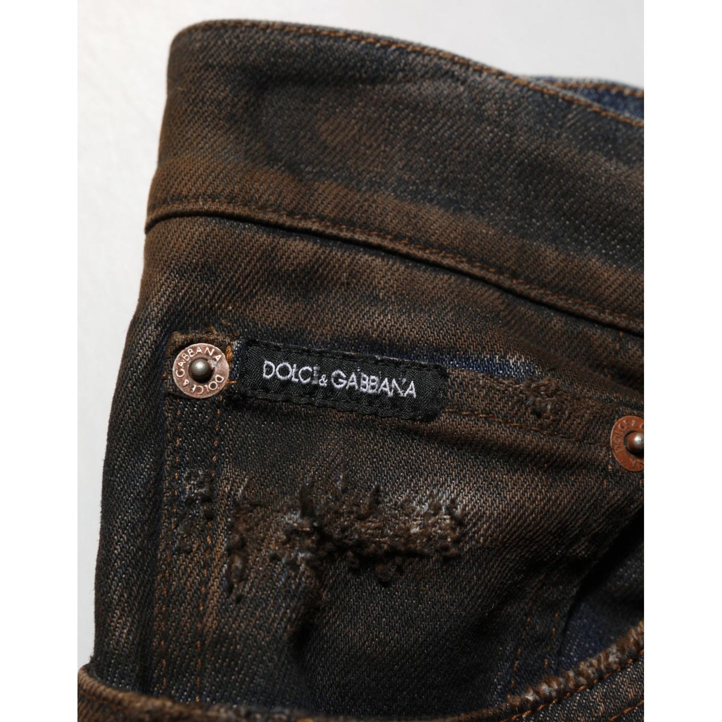Close-up of Dolce & Gabbana Black Cotton Skinny Tattered Men Denim Jeans showing brand label and distressed details.