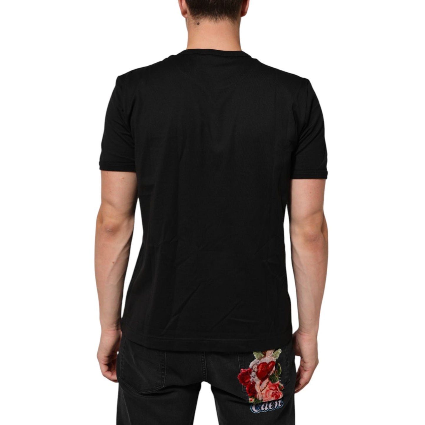 Back view of model wearing Dolce & Gabbana Black Goodluck 2021 Cotton Crew Neck T-shirt, showcasing black cotton fabric and fit.