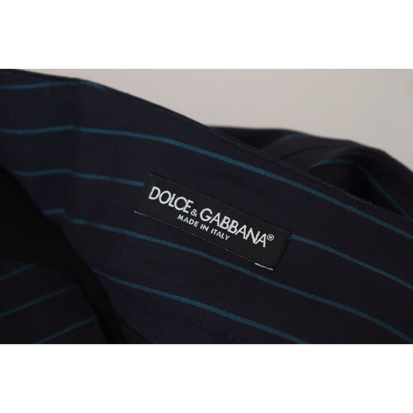 Dolce & Gabbana Blue Striped Men Formal Pants label, made in Italy, showing logo and striped pattern, 100% virgin wool fabric.
