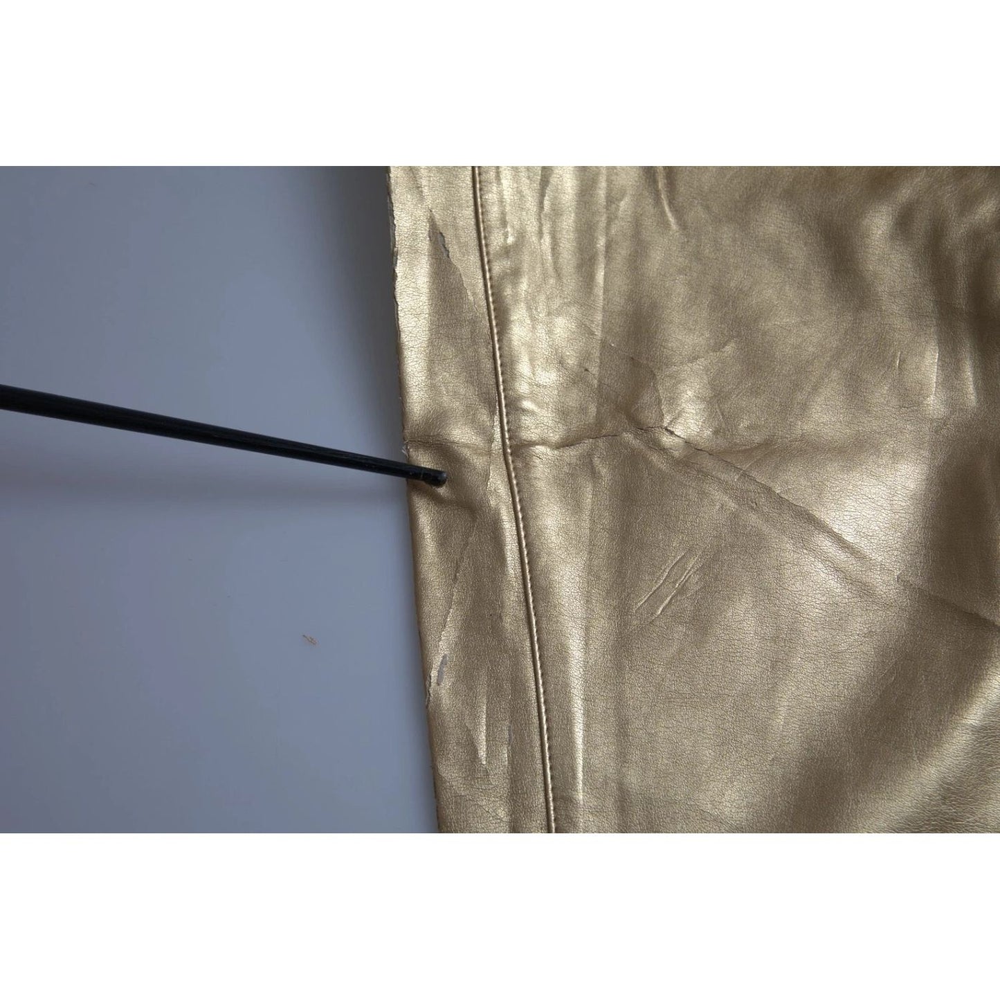 Close-up of Dolce & Gabbana Gold High Waist Skinny Women Metallic Pants showing minor defect with missing color detail.