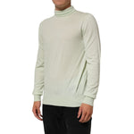 Model wearing Dolce & Gabbana Light Green Logo TurtleNeck Pullover Sweater made of 100% virgin wool with ribbed hem.