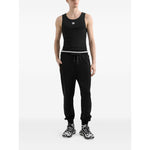 Model wearing Dolce & Gabbana Logo cotton tank top, black with embroidered logo, sleeveless, round neck, straight hem.
