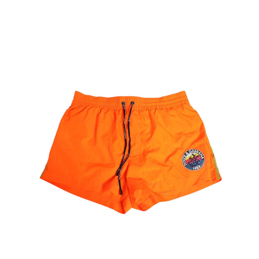 Dolce & Gabbana Orange Polyester Beachwear Men Shorts Swimwear with elastic drawstring waistband and logo detail.