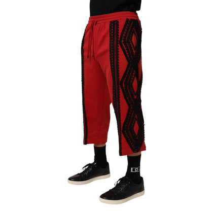 Model wearing Dolce & Gabbana Red Embroidered Casual Cropped Trouser Pants with black shoes and socks, showcasing detailed embroidery.