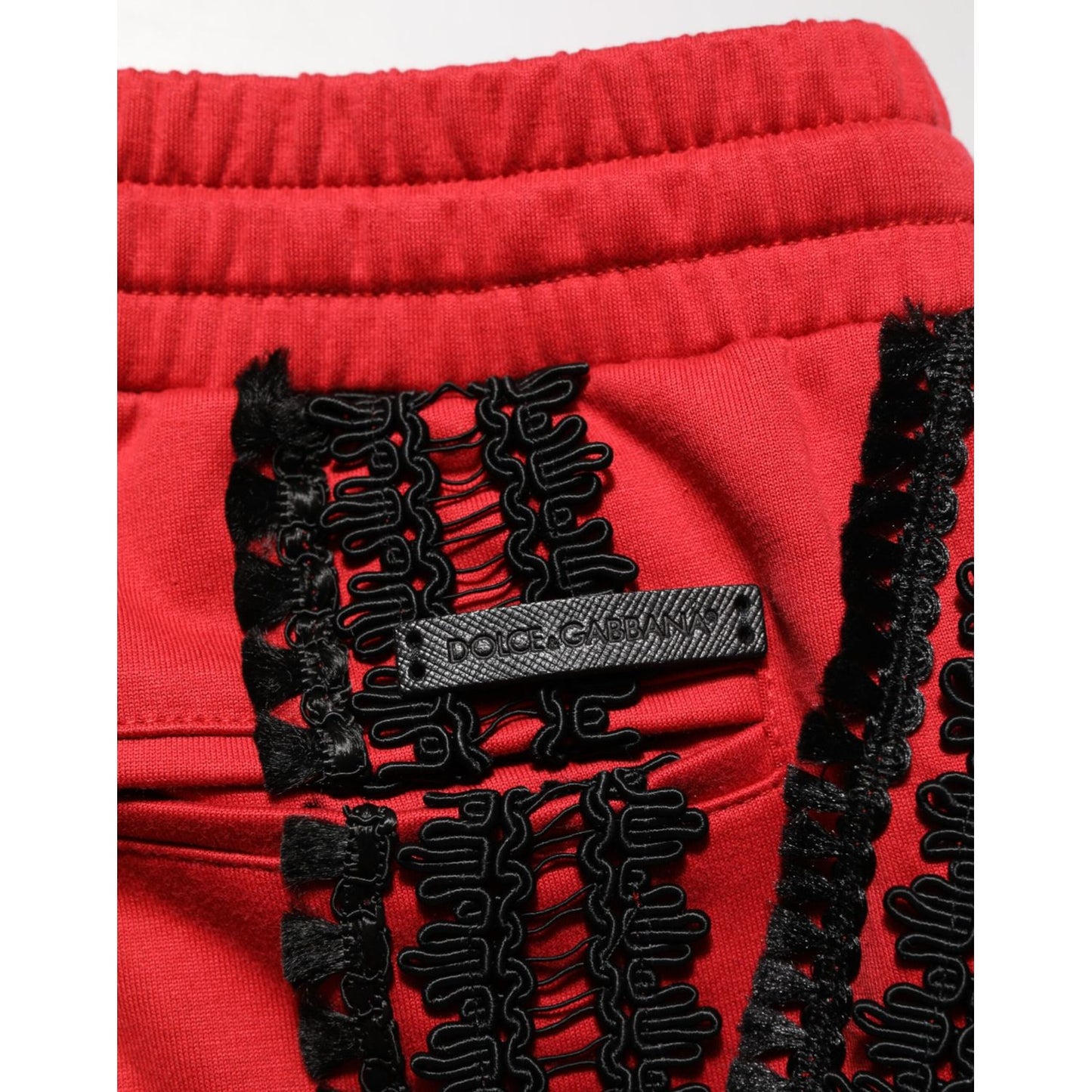 Close-up of Dolce & Gabbana Red Embroidered Casual Cropped Trouser Pants showcasing intricate black embroidery detail.
