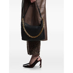 Emporio Armani Medium leather hobo bag with chain in black leather, held by model, showcasing gold-tone chain detail.