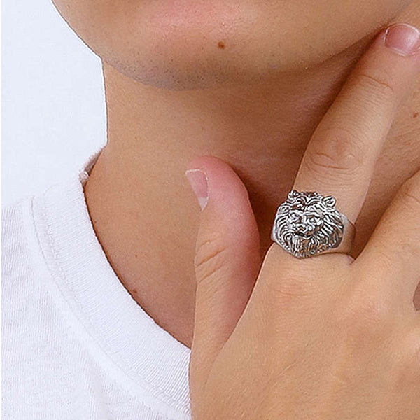 Close-up of a person wearing a silver lion ring on their finger, showcasing intricate design and bold style.