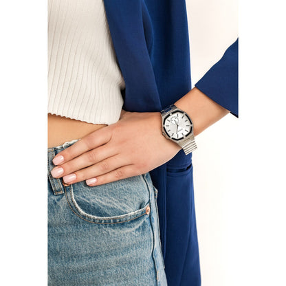 Fashionable woman wearing GUESS Mod. GW0310L1 silver quartz analog watch with blue outfit and jeans.