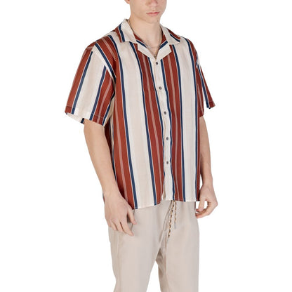 Model wearing a striped short-sleeve shirt with red, white, and blue vertical lines paired with beige trousers, perfect for casual wear.