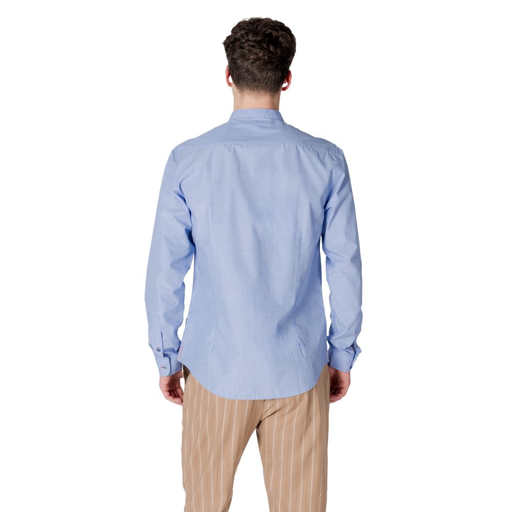 Back view of a man wearing a Gianni Lupo Light Blue Cotton Shirt with long sleeves.