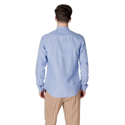 Back view of a man wearing a Gianni Lupo Light Blue Cotton Shirt with long sleeves.
