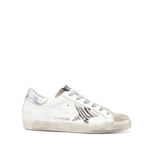Golden Goose Super Star low-top sneaker, cloud white leather with star patch, metallic heel, and flat rubber sole, side view.
