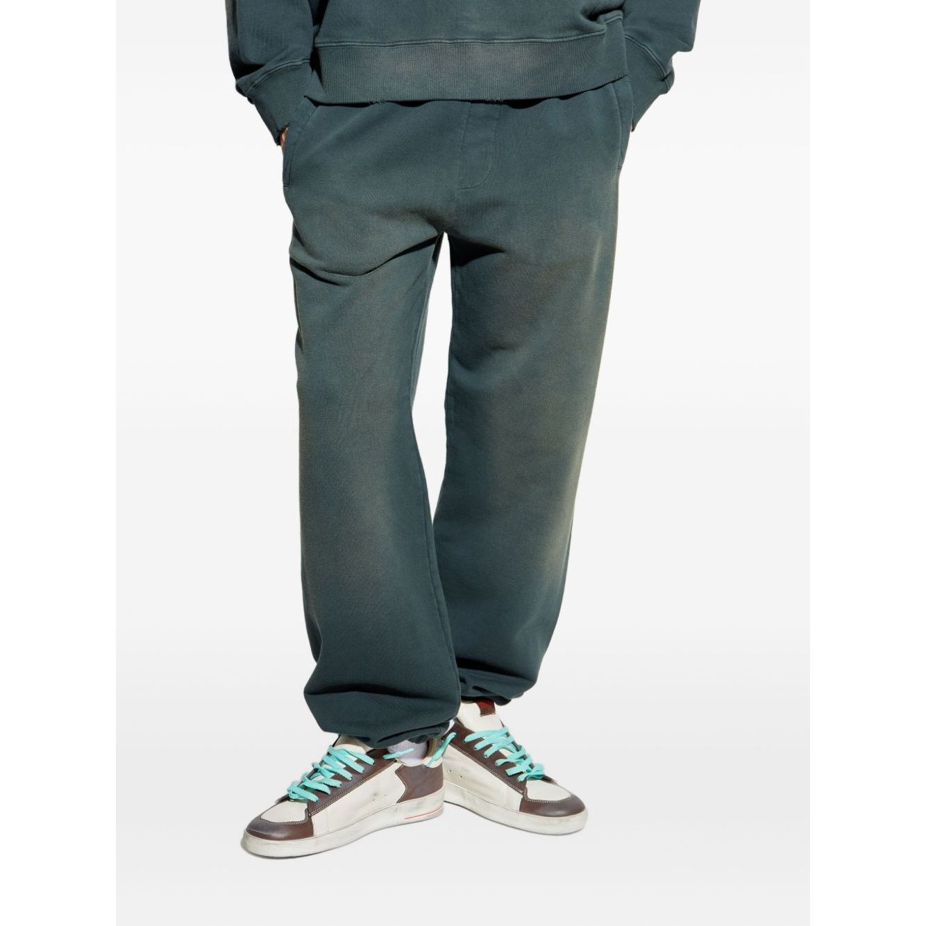 Person wearing Golden Goose Trousers Black with blue elasticated waistband and sneakers, showcasing embroidered logo and cotton fabric.