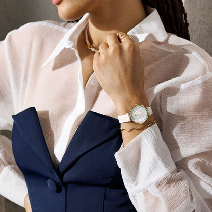 Woman wearing SKAGEN Mod. ANITA LILLE wristwatch with mother of pearl dial and leather strap in a stylish setting.