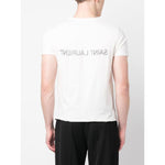 Back view of Saint Laurent Logo T-shirt with reverse logo print, white cotton, short sleeves, round neck, model wearing size M, black pants.