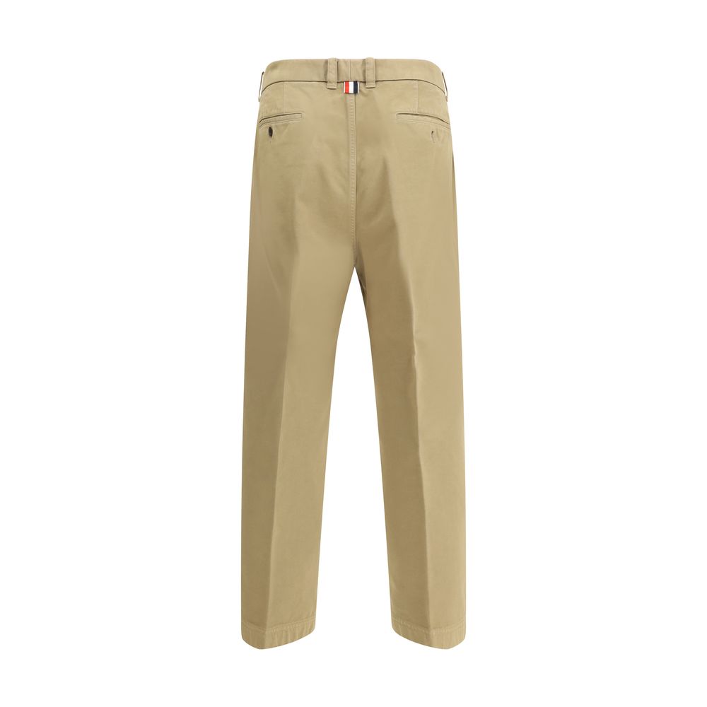 Thom Browne Cotton Pants, beige straight-leg with tricolor patch, showing back view and buttoned welt pockets.