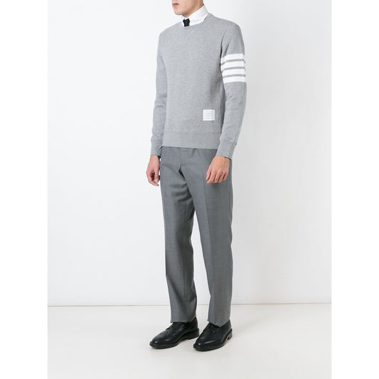 Model wears Thom Browne Sweaters Grey with 4-Bar stripe, ribbed trims, and button side fastening, crafted from loopback cotton jersey.